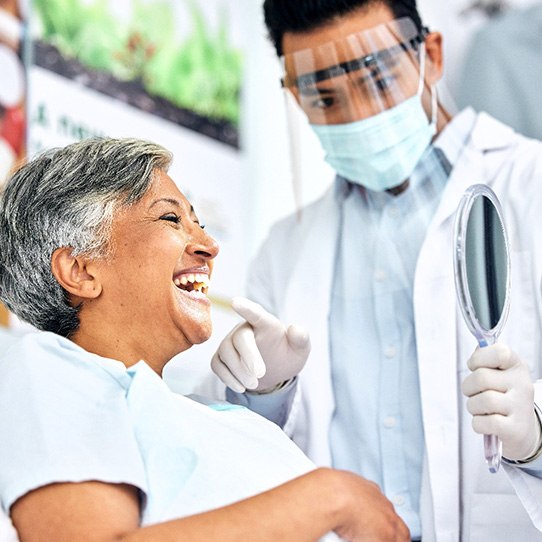 Dentist pointing to smiling patient's teeth