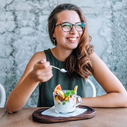 Smiling woman eating healthy breakfast at home